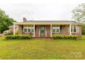 Inviting brick home featuring a covered front porch with supportive columns and manicured landscaping at 1162 E Doc Garris Rd, Lancaster, SC 29720