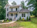 Inviting two-story home boasts a charming front porch and lovely landscaped front yard at 1256 Canseco Ln, Hickory, NC 28602
