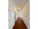 Inviting hallway with hardwood floors, wainscoting, and neutral paint, leading to a bright and airy living space at 1304 Ridge Haven Rd, Waxhaw, NC 28173