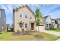 Inviting two-story tan home with a well-manicured lawn, two-car garage, and appealing curb appeal at 13140 Sudwick Ln, Charlotte, NC 28278