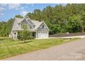 Two-story home with manicured lawn, mature trees, and a two-car garage at 148 Powder Spring Dr, Statesville, NC 28677