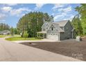 Beautifully landscaped two-story home featuring a large lawn and a two-car garage at 148 Powder Spring Dr, Statesville, NC 28677