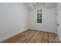 White bedroom featuring wood floors and a window for natural light at 1520 Enochville Rd, Kannapolis, NC 28081