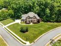 Expansive aerial view of a stately brick home surrounded by mature trees and a well-maintained yard at 1600 Buckland Ct, Indian Land, SC 29707