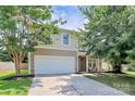 Inviting two-story home showcasing a two-car garage, a cozy front porch, and lush trees at 1817 Tradd Ave, Clover, SC 29710