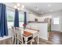 Bright dining area featuring a wood table, seating for four, modern lighting, and views of the kitchen at 218 Canina Ln, Indian Trail, NC 28079
