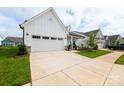 Beautiful white single-story home, showcasing its attached two-car garage and pristine driveway at 25952 Appleyard Ct, Lancaster, SC 29720