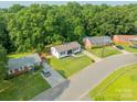 An aerial view showcases homes with green lawns on a tree lined street at 3608 Crestridge Dr, Charlotte, NC 28217