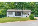Newly renovated home with a well-maintained lawn, white painted brick, and stylish black accents at 3608 Crestridge Dr, Charlotte, NC 28217