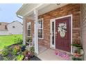 Welcoming front porch with a brick facade, decorative front door with floral wreath, and well-tended flower garden at 4006 Centerview Dr, Indian Trail, NC 28079