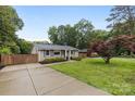 Inviting ranch home with a manicured lawn, mature trees, and a paved driveway leading to the entrance at 5008 Unaka Ave, Charlotte, NC 28205