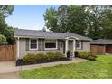 Beautiful single story home with mature trees, painted brick, grey shutters, and inviting front entrance at 5008 Unaka Ave, Charlotte, NC 28205