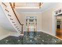 Grand foyer with elegant marble flooring and a staircase showcasing the home's architectural details and spacious design at 517 Kingsdown Ct, Waxhaw, NC 28173