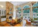 Elegant living room boasts soaring ceilings, large windows, a stone fireplace and refined decor adding warmth and grandeur at 517 Kingsdown Ct, Waxhaw, NC 28173