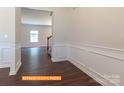 View of the foyer featuring wainscoting, luxury vinyl flooring, and an open entryway to the living spaces at 524 Hullview Vis, Monroe, NC 28110