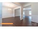 Open-concept living area with dark luxury vinyl flooring, wainscoting, chandelier and views to the next room at 524 Hullview Vis, Monroe, NC 28110