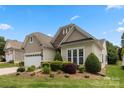 Beautiful exterior showing a well-maintained lawn and colorful landscaping, complete with a two-car garage at 56113 Finches Ct, Indian Land, SC 29707
