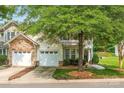 Charming home with stone accents, a two-car garage, and lush landscaping on a sunny day at 5963 Pale Moss Ln, Charlotte, NC 28269