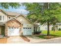 Charming home with stone accents, a two-car garage, and lush landscaping on a sunny day at 5963 Pale Moss Ln, Charlotte, NC 28269