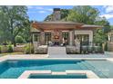 Inviting backyard oasis with a sparkling pool, stone fireplace, and comfortable seating area at 639 Edgemont Rd, Charlotte, NC 28211