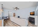 Bright living room with a fireplace, ceiling fan, hardwood floors, and comfortable furnishings at 6834 Creft Cir, Indian Trail, NC 28079