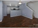 Open-concept living area with wood-look flooring, steps to second floor, and kitchen view at 7623 Monarch Birch Ln, Charlotte, NC 28215