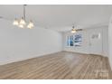 Bright living room with hardwood floors, chandelier, ceiling fan, large windows, and neutral walls at 81 Kirk St, Salisbury, NC 28144