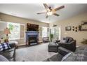 Cozy living room featuring a fireplace, ceiling fan, neutral color palette, and lots of natural light at 8232 Bretton Woods Dr, Charlotte, NC 28227