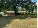 Spacious, shaded backyard with mature trees offers a serene and private outdoor space at 8616 Fallsdale Dr, Charlotte, NC 28214