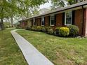 Well-maintained single-story brick home with manicured landscaping and a paved walkway at 8616 Fallsdale Dr, Charlotte, NC 28214