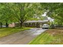 Brick home with an expansive driveway, green shutters, and charming decorative window boxes at 1005 Fieldstone Rd, Mooresville, NC 28115