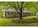 Inviting brick home with green shutters, beautiful landscaping, and a mature shade tree at 1005 Fieldstone Rd, Mooresville, NC 28115