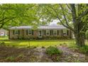 Quaint brick home featuring green shutters, flower-filled window boxes, and a lush front lawn at 1005 Fieldstone Rd, Mooresville, NC 28115
