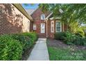 Inviting front entrance of a red brick home with a well-maintained walkway and manicured landscaping at 104 Fairwind Ct, Fort Mill, SC 29708