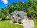 Spacious home featuring a manicured lawn, multi-car garage, and lush landscaping at 122 Laurel Glen Dr, Mooresville, NC 28115