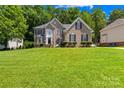 Charming two-story brick home with lush green lawn, landscaped yard, and inviting curb appeal at 122 Laurel Glen Dr, Mooresville, NC 28115
