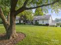 Beautifully landscaped front yard with mature trees and a well-maintained one-story home at 22501 John Gamble Rd, Cornelius, NC 28031