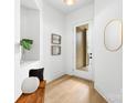 Bright foyer featuring light wood floors, a modern mirror, and built-in shelving with stylish decor at 2413 Pruitt St, Charlotte, NC 28208