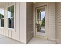 Exterior view of a beige home's front door and window, showcasing the home's facade and natural light at 2413 Pruitt St, Charlotte, NC 28208
