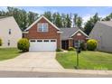 Inviting brick home featuring a well-maintained lawn and a two-car garage at 2448 Sweet Birch Ct, Gastonia, NC 28054