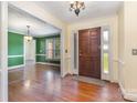 Inviting home entryway boasts hardwood floors, complemented by neutral walls and a solid wooden front door at 2627 Willis Dr, Harrisburg, NC 28075