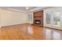 Bright living room with hardwood floors, a brick fireplace, and French doors leading to the backyard at 2627 Willis Dr, Harrisburg, NC 28075