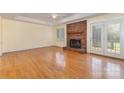 Bright living room with hardwood floors, a brick fireplace, and French doors leading to the backyard at 2627 Willis Dr, Harrisburg, NC 28075
