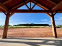 View from covered porch of this new construction home, overlooking field and blue sky at 3000 Paul Payne Store Rd, Taylorsville, NC 28681
