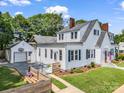 Charming two-story home with white siding, black shutters, an American flag and detached garage at 329 E Congress St, Lincolnton, NC 28092