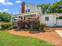 Charming home featuring a side porch framed by a brick pathway and well-maintained shrubs at 329 E Congress St, Lincolnton, NC 28092