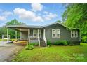 View of the home featuring a cozy front porch, covered parking, mature landscaping, and a well-manicured lawn at 3810 Biggers Rd, York, SC 29745