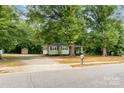 Charming light yellow home with a covered porch and mature shade trees at 39 Selma Dr, Mooresville, NC 28115