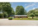 Well-maintained brick home with lush lawn, attached two-car garage, and mature trees at 400 S Westover Dr, Monroe, NC 28112