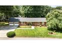 Well-maintained brick home featuring lush lawn, an attached two-car garage, and mature trees at 400 S Westover Dr, Monroe, NC 28112